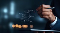 Male hand in business suit drawing electronic circuit diagram on virtual screen with digital pen, blurred city lights background creates futuristic atmosphere.