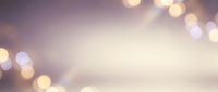 Soft purple and pink gradient background with warm golden bokeh lights creating dreamy atmosphere for romantic designs and elegant presentations.