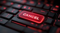 Close-up of red illuminated cancel button on dark keyboard with glowing keys, representing rejection, termination, or abort action in digital interface design.