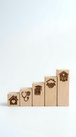 Wooden blocks arranged in ascending staircase with engraved icons representing home, healthcare, education, partnership, and family growth concepts.