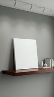 Minimalist wooden shelf with blank white canvas and ceramic vases on gray wall with track lighting for modern interior design and home decor mockup.