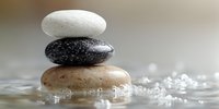 Balanced zen stones stacked in water with bubbles, creating a serene spa atmosphere for wellness, meditation, and relaxation practices.