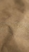 Close-up macro view of natural brown leather texture with visible grain patterns and soft focus background for luxury fashion and craft projects.