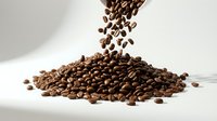 Roasted coffee beans pouring onto a pile against white background, isolated for beverage, food and cafe design projects.
