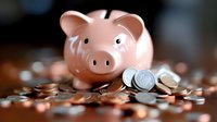 Pink ceramic piggy bank surrounded by scattered coins on dark surface, shallow depth of field focus on savings concept for financial planning and money management.
