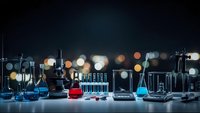 Laboratory glassware with colorful chemical solutions on dark background with bokeh lights for scientific research and experimentation.
