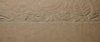 Close-up of detailed shoe sole tread pattern imprinted in fine sand showing textured grip design for footwear and walking concepts.