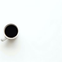 White coffee mug with black coffee on clean white background with copy space for text and design elements.