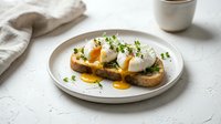 Poached eggs with runny yolk on toasted bread garnished with fresh herbs served on white plate. Gourmet breakfast or brunch dish for restaurant menu design.
