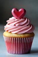 Valentine's Day cupcake with pink frosting and red heart topper for romantic celebration dessert bakery treats and holiday sweets.