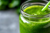 Fresh green smoothie in glass jar with straw, healthy detox drink made from leafy vegetables and fruits for wellness nutrition and clean eating lifestyle.