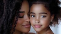 African American mother and daughter sharing tender moment with natural curly hair, warm lighting creates intimate family bond for Mother's Day campaigns.