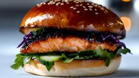 Grilled salmon burger with fresh vegetables and purple cabbage on brioche bun, garnished with sesame seeds, close up view on blurred background.