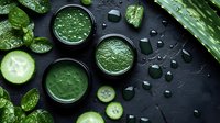 Fresh green smoothie with cucumber, spinach and aloe vera on dark background with water drops. Healthy detox drink for wellness and diet.