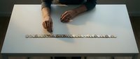 Male hands arranging metallic coins in a line on white surface, representing financial planning, savings growth, and wealth management concepts for business and investment themes.