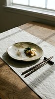 Minimalist Asian cuisine plating with seafood and vegetables on ceramic dish, wooden chopsticks, natural linen placemat, sunlit wooden table setting.