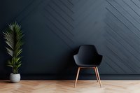 Modern black armchair with wooden legs against dark geometric wall paneling and potted palm plant on herringbone floor, minimalist interior design concept.