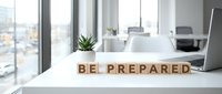 Be prepared wooden blocks on modern office desk with city view windows, laptop and succulent plant for business readiness and planning concepts.