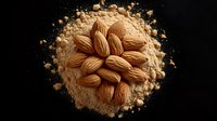 Fresh whole almonds arranged in circular pattern on scattered almond flour against black background, dramatic food photography for packaging design.