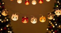 Festive cat face string lights with warm glowing bulbs and bokeh background, perfect for holiday decorations, seasonal marketing, and festive event designs.