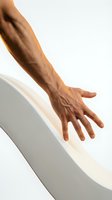 Male hand with medium brown skin tone touching white curved surface, demonstrating tactile interaction and smooth material contact for design and product concepts.