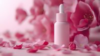 Pink cosmetic dropper bottle surrounded by delicate rose petals and blossoms in soft focus, creating romantic spa and beauty product composition.