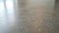 Close-up of polished concrete floor surface with subtle texture and light reflection, suitable for interior design, construction, and architectural projects.