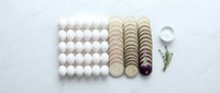 Organized craft supplies including white foam balls, wooden discs, metal ring and decorative elements arranged on white background for DIY projects.
