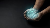 Male hands holding glowing transparent cube with digital holographic effects against dark background for technology and innovation concepts.