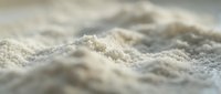 Macro close-up of fine white powder or flour with shallow depth of field, suitable for baking, cooking, and food industry applications.