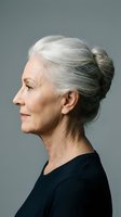 Elegant senior woman with silver gray hair in profile view wearing black top against neutral background for aging and beauty concepts.