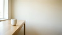 Minimalist wooden table with white cup near bright window in empty beige room, suitable for interior design, lifestyle, and home decor projects.