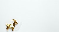 Geometric gold goat sculpture isolated on white background, modern minimalist art object for interior design and decorative home styling.