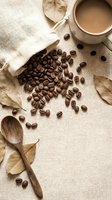 Coffee beans scattered on burlap with wooden spoon and cup creating rustic morning beverage scene for cafe branding and kitchen decor projects.