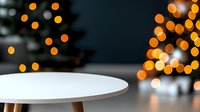 Minimalist white table against blurred Christmas lights background with orange bokeh effect creates modern festive atmosphere for product display.