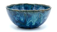 Handmade ceramic bowl with deep blue glaze and organic texture, isolated on white background. Suitable for home decor, tableware, and product photography.