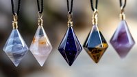 Five handcrafted crystal pendant necklaces with wire wrapping display various gemstones in geometric diamond shapes on black cords for jewelry making.