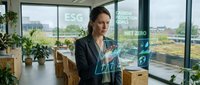 Professional businesswoman analyzing ESG sustainability data on holographic interface in modern eco-friendly office with city view and green plants.