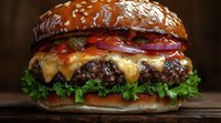 Juicy cheeseburger with melted cheese, fresh lettuce, tomatoes, red onions and sauce on sesame seed bun, close up view on dark background.