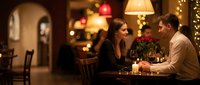 Young couple enjoying romantic dinner date in cozy restaurant with warm lighting and festive decorations, perfect for Valentine's Day celebration.