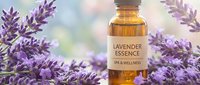 Lavender essential oil bottle surrounded by fresh purple lavender flowers for aromatherapy, spa treatments, natural wellness and relaxation therapy.