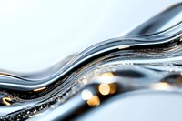 Abstract flowing liquid waves in black and silver with golden light bokeh effects create dynamic luxury background pattern for elegant designs.
