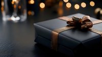 Luxury black gift box with bronze ribbon bow on dark surface, warm golden bokeh lights in background, elegant present for special occasions and celebrations.