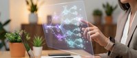 Professional woman examining transparent digital display with glowing network connections and data visualization in modern office environment.