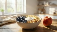 Breakfast bowl with granola, yogurt and blueberries on wooden table near window, healthy morning meal and nutrition concept for wellness and diet.