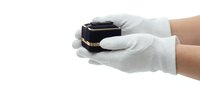 Hands in white cotton gloves holding luxury black and gold jewelry box on white background, isolated for product presentation and retail design use.