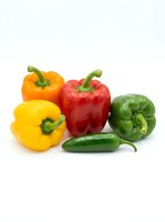 Fresh bell peppers and green chili isolated on white background. Colorful vegetables including yellow, red, orange and green peppers with jalapeño for cooking, recipes, healthy eating and nutrition.