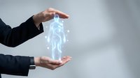 Person in dark business suit holding glowing digital human figure between hands, representing artificial intelligence, technology innovation, and future digital transformation concepts.