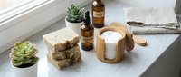 Natural handmade soap bars with essential oil bottles and succulents on marble surface. Organic skincare products for spa and wellness routines.