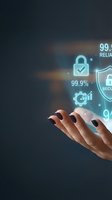 Hand of a woman with dark nail polish holding digital security icons including padlock, shield, and reliability percentages against dark background for cybersecurity and data protection concepts.